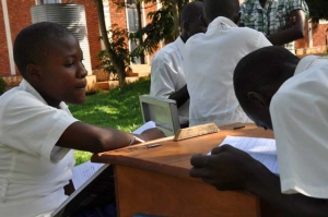 A visually-impaired student takes down the notes from one of the sighted girls.