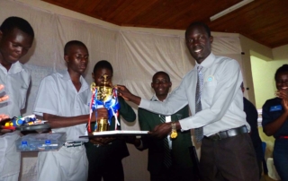 Students of Kiira College Butiiki receive their trophy aftr winning the National Science & Technology Challenge at Gulu University